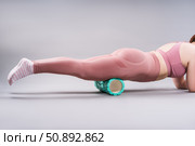 Fat woman in sportswear use myofascial release massage mfr roll on gray background, pelvic floor muscle exercise. Стоковое фото, фотограф Станислав Тарко / Фотобанк Лори