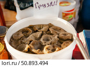 Inscription on the price tag: Grusdi - means Milk mushrooms: Altai pickled mushrooms in a plastic bucket at the fair. Стоковое фото, фотограф Екатерина Красникова / Фотобанк Лори