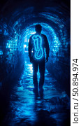 Gastrointestinal Health Concept: A man walking in a blue tunnel with a glowing digestive system overlay. Стоковое AI-изображение, AI-художник Данила Большаков / Фотобанк Лори