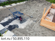 Construction site with wheelbarrow and spade on sand. Стоковое фото, фотограф Nobilior / Фотобанк Лори