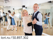 Man and elderly woman performing ballroom dance in dancing room. Стоковое фото, фотограф Татьяна Яцевич / Фотобанк Лори