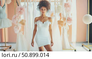 Radiant beauty in a modern white lace-top mini dress at an exclusive garment showroom. Стоковое AI-видео, аниматор Данила Большаков / Фотобанк Лори
