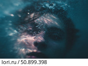 Person submerged underwater with light reflections and bubbles creating a serene, dreamlike atmosphere in a natural setting. Стоковое AI-изображение, AI-художник Сергей Толмачёв / Фотобанк Лори