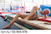 Injured female gymnast suffering from knee pain after bad landing. Стоковое фото, фотограф Татьяна Яцевич / Фотобанк Лори