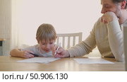 Dad teaches his son writing and counting. Kids primary education. Children learn, study in home school. Daddy male helping teaching little child boy support studying, learning homework. Knowledge day. Стоковое видео, видеограф Марина Демидюк / Фотобанк Лори