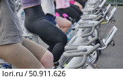 Athletes pedaling on exercise bikes during sports day. Стоковое видео, видеограф Mikhail Davidovich / Фотобанк Лори