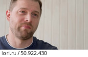 Handsome young man in blue jersey indoors. Male with stylish haircut, beard feel happy, calm and serious. Home interior background. Man looking to camera and into distance. Diversity People. Portrait. Стоковое видео, видеограф Марина Демидюк / Фотобанк Лори