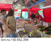 Городская ярмарка в центре города. Палатка с рыбой и морепродуктами. Продавцы раскладывают продукцию на прилавке, покупатели выбирают, что купить. Вагенинген. Нидерланды. Редакционное фото, фотограф Мария Фетисова / Фотобанк Лори