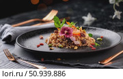 Colorful quinoa salad adorned with edible flowers, nuts, dried fruits, resting on dark textured plate with refined culinary styling. Стоковое AI-видео, аниматор Данил Руденко / Фотобанк Лори