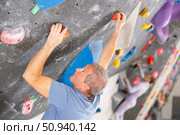 Male mountaineer climbing artificial rock wall without belay indoors. Стоковое фото, фотограф Яков Филимонов / Фотобанк Лори