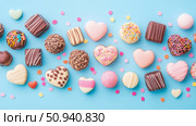 Sweet Valentine's Day chocolate assortments on blue backdrop for festive card, party, and advertising material. Стоковое AI-изображение, AI-художник Данила Большаков / Фотобанк Лори