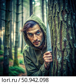 Maniac Hiding With a Knife in the Forest. Generative AI. Стоковое AI-изображение, AI-художник Roman Zavorotny / Фотобанк Лори
