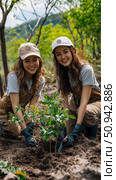 Environmental concept: Two women planting sapling for reforestation and conservation, celebrating Earth Day. Стоковое AI-изображение, AI-художник Данила Большаков / Фотобанк Лори