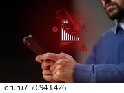 Tracking cryptocurrency trends with mobile app during market fluctuations at home in evening hours. Стоковое фото, фотограф Сергей Толмачёв / Фотобанк Лори