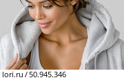 Woman wearing a cozy hoodie with a comfortable smile in indoor setting. Стоковое AI-изображение, AI-художник Katsiaryna Repich / Фотобанк Лори