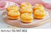 Exquisite Lemon Cream Cupcakes on a Wooden Board: A Culinary Delights Display for Food Lovers and Dessert Enthusiasts. Стоковое AI-изображение, AI-художник Данила Большаков / Фотобанк Лори