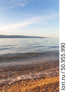 Landscape of Baikal Lake at sunset. Olkhon Island. Sandy and pebbles beach of Small Sea with pure transparent clear water in July hot day. Natural background. Summer travel and seaside recreation. Стоковое фото, фотограф Виктория Катьянова / Фотобанк Лори