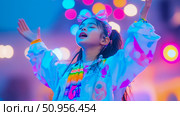 A jubilant child with a bright pink bow headband, arms raised in bliss, immersed in a spectrum of neon illumination, capturing a moment of pure euphoria, ideal for music events or celebration promoti. Стоковое AI-изображение, AI-художник Данила Большаков / Фотобанк Лори