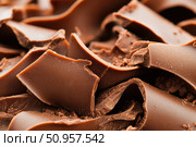 A close-up showcases rich, dark chocolate curls with a glossy finish. These luxurious chocolate decorations are perfect for any gourmet dessert presentation, reflecting the art of confectionery. Стоковое AI-изображение, AI-художник Nart / Фотобанк Лори