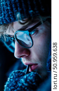 Intimate portrait of a pensive young man in round spectacles and warm knitwear, bathed in striking cool blue illumination, creating a serene winter concept. Стоковое AI-изображение, AI-художник Данила Большаков / Фотобанк Лори