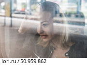 Woman traveler contemplating outdoor view from window of train. Young lady on commute travel to work sitting in bus or train. Стоковое фото, фотограф Matej Kastelic / Фотобанк Лори