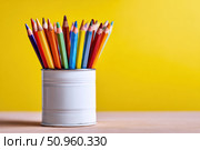Close-Up of Vibrant Colorful Pencils in a pen holder isolated on yellow background. Banner, copy space. Colourful sharpened colored pencils for art projects, drawing, and creativity. Back to school. Стоковое AI-изображение, AI-художник Марина Демидюк / Фотобанк Лори