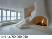 Modern minimalist interior with organic shapes: a white curved staircase leads to a fireplace with a live fire. The interior is designed in a soft monochrome style, with panoramic windows opening up to a view of the snowy landscape. The space is filled with light, warmth and a sense of coziness, despite the strict palette. Ideal for themes on architecture, interior design, privacy, winter cozy plots. Стоковое AI-изображение, AI-художник Анна Кривицкая / Фотобанк Лори