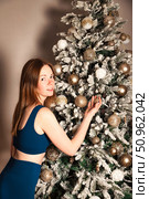 Decorating Christmas Tree Brings Joy to This Pretty Woman. Стоковое фото, фотограф Aleksandr Golubev / Фотобанк Лори