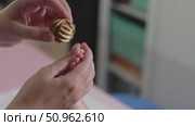 Slow-motion video of a textured juniper wood ball massaging an infant's toes. Gentle pediatric reflexology and sensory stimulation. Стоковое видео, видеограф Татьяна Степанищева / Фотобанк Лори
