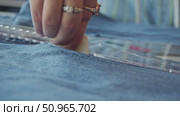 A small piece of chalk used by a tailor to mark a line on denim clothing, which serves as a guide for their work. Стоковое видео, видеограф Strunov David / Фотобанк Лори