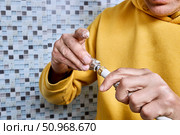 Applying plumbing paste to fitting, plumber prepares compression coupling for easier insertion of fitting into multilayer pipe, assembling connection without additional materials. Стоковое фото, фотограф Владимир Григорьев / Фотобанк Лори