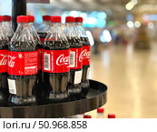 A row of Coca-cola bottles on a shelf. Russia. Moscow. 02.08.25. Редакционное фото, фотограф Ярославский Максим / Фотобанк Лори