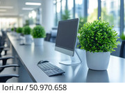 Modern office with workstations in a bright open space. In the foreground is a computer with a keyboard and mouse, and next to it is a decorative green plant in a white pot. The office is decorated in a minimalist style, with an emphasis on ecology and comfort. Panoramic windows fill the room with natural light. Suitable for illustrating themes of productivity, eco-design, remote work, corporate environment and business interiors. Стоковое AI-изображение, AI-художник Анна Кривицкая / Фотобанк Лори