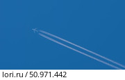 High-flying jet leaves contrail in clear blue sky. Стоковое видео, видеограф Игорь Жоров / Фотобанк Лори