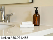 Soft white towels rest neatly by a sleek sink, while a bottle of liquid soap adds elegance. This tranquil bathroom scene evokes calmness and simplicity in watercolor art Generative AI. Стоковое AI-изображение, AI-художник Юлия Петровская / Фотобанк Лори