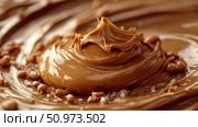 An inviting close-up of thick, glossy peanut butter or caramel spreading, with artful peaks and valleys, speckled with crunchy bits and flecks of salt, emphasizing its rich texture. Стоковое AI-изображение, AI-художник Данила Большаков / Фотобанк Лори