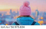 Solitary traveler, clad in a cozy pink knit hat, gazes upon the soft, blurred glow of an urban landscape at tranquil dawn. Стоковое AI-видео, аниматор Данила Большаков / Фотобанк Лори