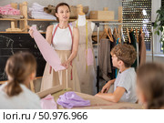 Woman teacher at blackboard conducts theoretical lesson for sewing school children students. Стоковое фото, фотограф Яков Филимонов / Фотобанк Лори