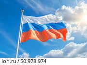 Флаг Российской Федерации развевается на фоне голубого неба солнечным днем. Стоковое AI-изображение, AI-художник Щеголева Ольга / Фотобанк Лори