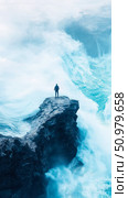 Solitary Figure on a Cliffside Amidst a Powerful Ocean Surge: A Dramatic Seascape. Стоковое AI-изображение, AI-художник Данила Большаков / Фотобанк Лори