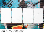 colorful urban wall with four wrinkled glued poster templates. Стоковое фото, фотограф Александра Конопля / Фотобанк Лори
