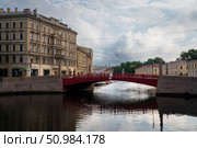 Saint Petersburg, Russia, July 21, 2024: View of the historical residential building of the K.B. Korpus Apartment Building on the Moika River embankment and the Red Bridge. Редакционное фото, фотограф Ula Ulachka / Фотобанк Лори