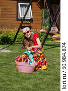 Teenage girl washes rag in pink basin. Стоковое фото, фотограф Андрей Аркуша / Фотобанк Лори