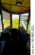 Abandoned control room of a train surrounded by overgrown vegetation in a rural area during daylight hours. Стоковое фото, фотограф Александра Рублева / Фотобанк Лори