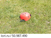 A red helmet on the green grass background. Стоковое фото, фотограф Татьяна Куклина / Фотобанк Лори