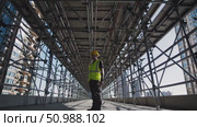 Construction worker wearing protective gear, balancing on scaffolding amid skyscrapers, supervising large scale urban development project with cityscape background. Стоковое AI-видео, аниматор Данил Руденко / Фотобанк Лори