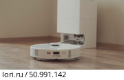 After cleaning the room robot vacuum heads back to the dock to recharge and empty the dust container automatically. Стоковое видео, видеограф Svetlana Golovco / Фотобанк Лори