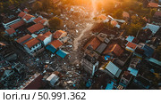 Sunset over a town devastated by an earthquake, showing the aftermath of natural disasters. Concept: Aftermath of natural disasters. For educational, humanitarian aid, and disaster recovery materials. Стоковое AI-изображение, AI-художник Лариса Пономарева / Фотобанк Лори