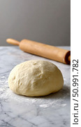 Fresh dough ball resting on marble surface with rolling pin. Стоковое фото, фотограф Юрий Поздников / Фотобанк Лори