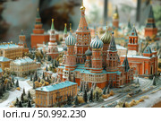A miniature model of the architectural ensemble of Red Square with a realistically recreated St. Basil's Cathedral, the Kremlin and surrounding buildings. The scene is decorated in a winter setting with detailed elaboration of trees, roofs and streets. Ideal for themes related to tourism, Russian history, architecture and cultural heritage. A magnificent combination of artistic skill and accuracy in conveying the image of Moscow. Стоковое AI-изображение, AI-художник Анна Кривицкая / Фотобанк Лори